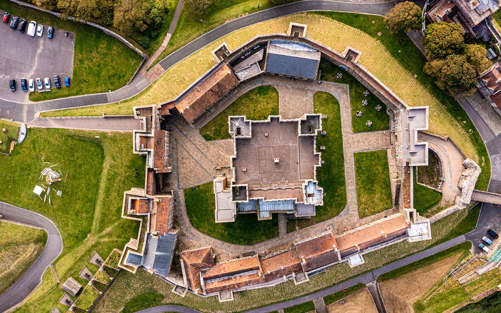 Aerial view of Dover Castle's medieval architecture and surrounding grounds in England.