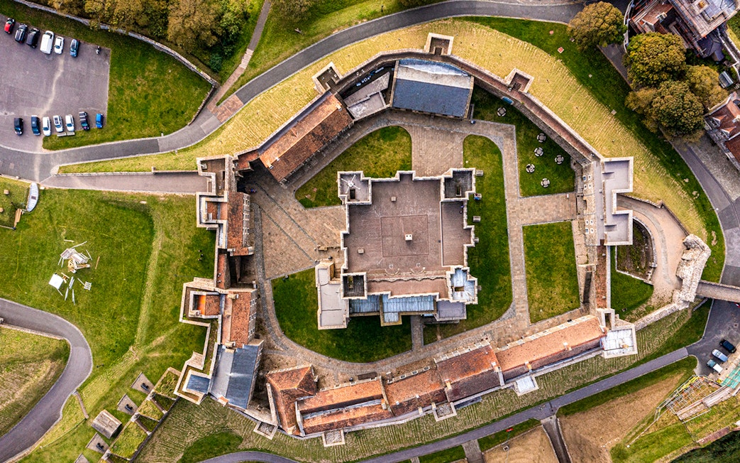 Aerial view of Dover Castle's medieval architecture and surrounding grounds in England.