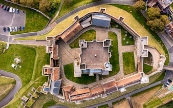 Aerial view of Dover Castle's medieval architecture and surrounding grounds in England.