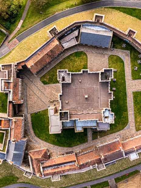 Aerial view of Dover Castle's medieval architecture and surrounding grounds in England.