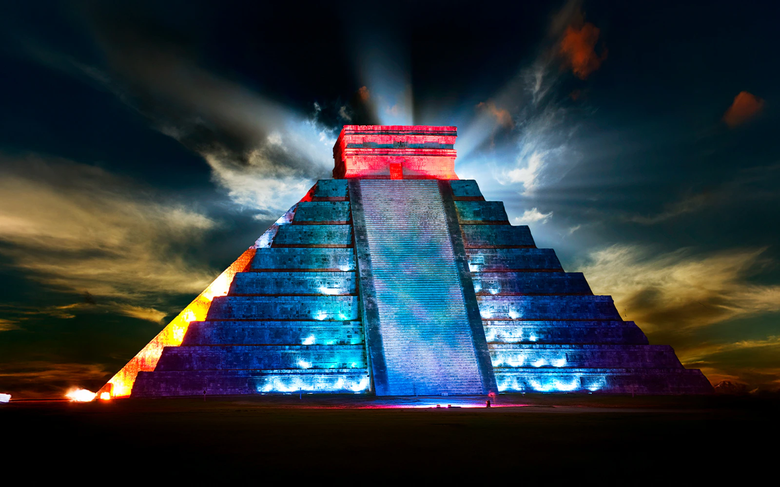 Chichen Itza pyramid illuminated during nighttime light show in Mexico.