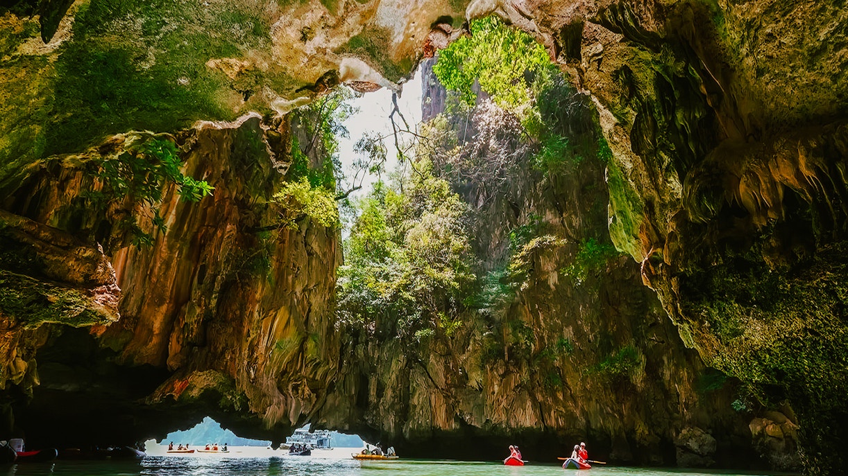 Kayakers exploring cave formations on James Bond Island tour.
