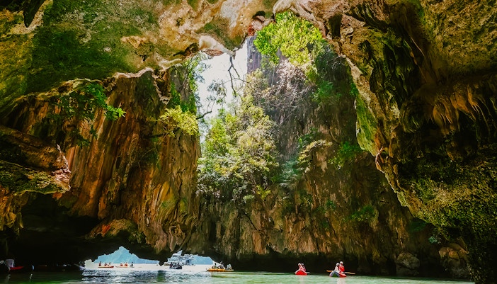 Kayakers exploring cave formations on James Bond Island tour.
