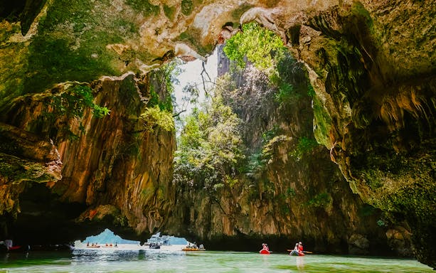 Kayakers exploring cave formations on James Bond Island tour.