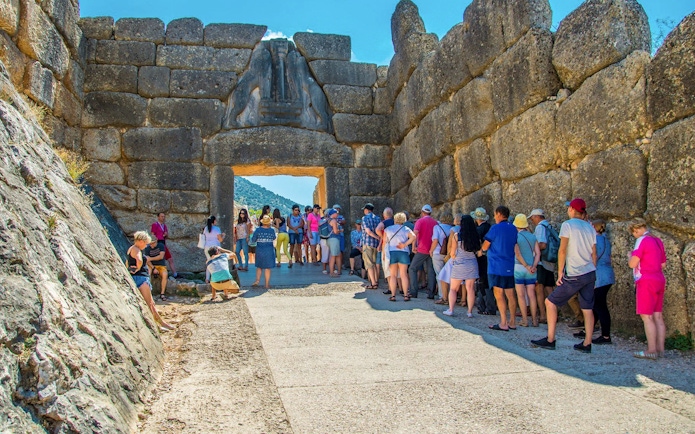 Visitors at the Lion Gate entrance of Mycenae archaeological site in Greece.