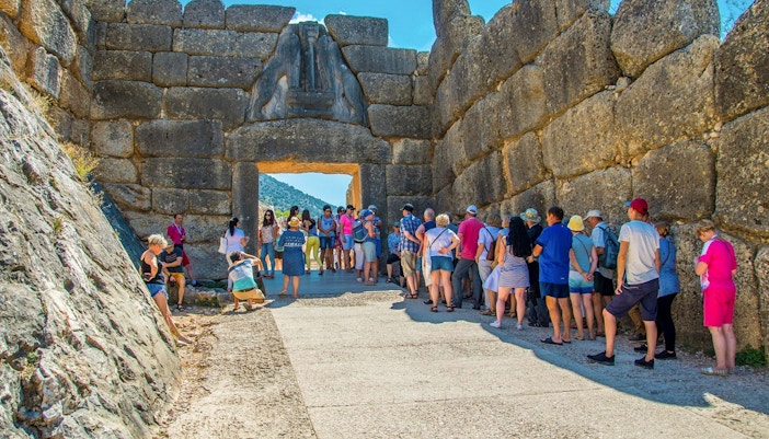 Visitors at the Lion Gate entrance of Mycenae archaeological site in Greece.