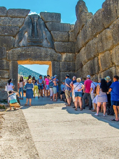 Visitors at the Lion Gate entrance of Mycenae archaeological site in Greece.