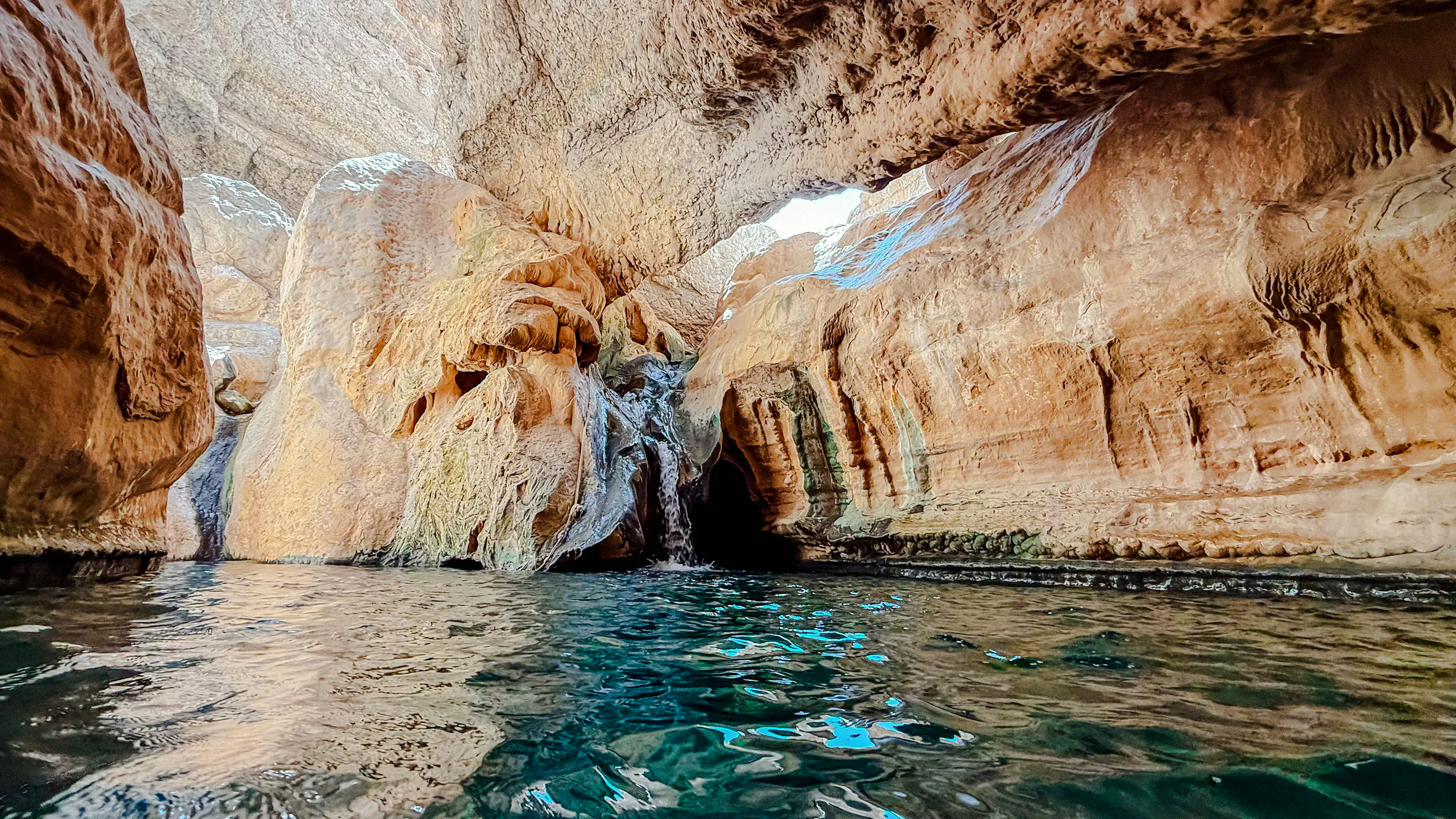 Rocky canyon with clear water at Wadi Shab, Oman, ideal for hiking and swimming.