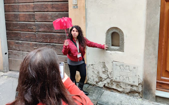 Tour guide in Florence explaining historical site to tourists.