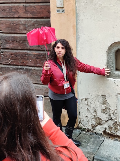 Tour guide in Florence explaining historical site to tourists.