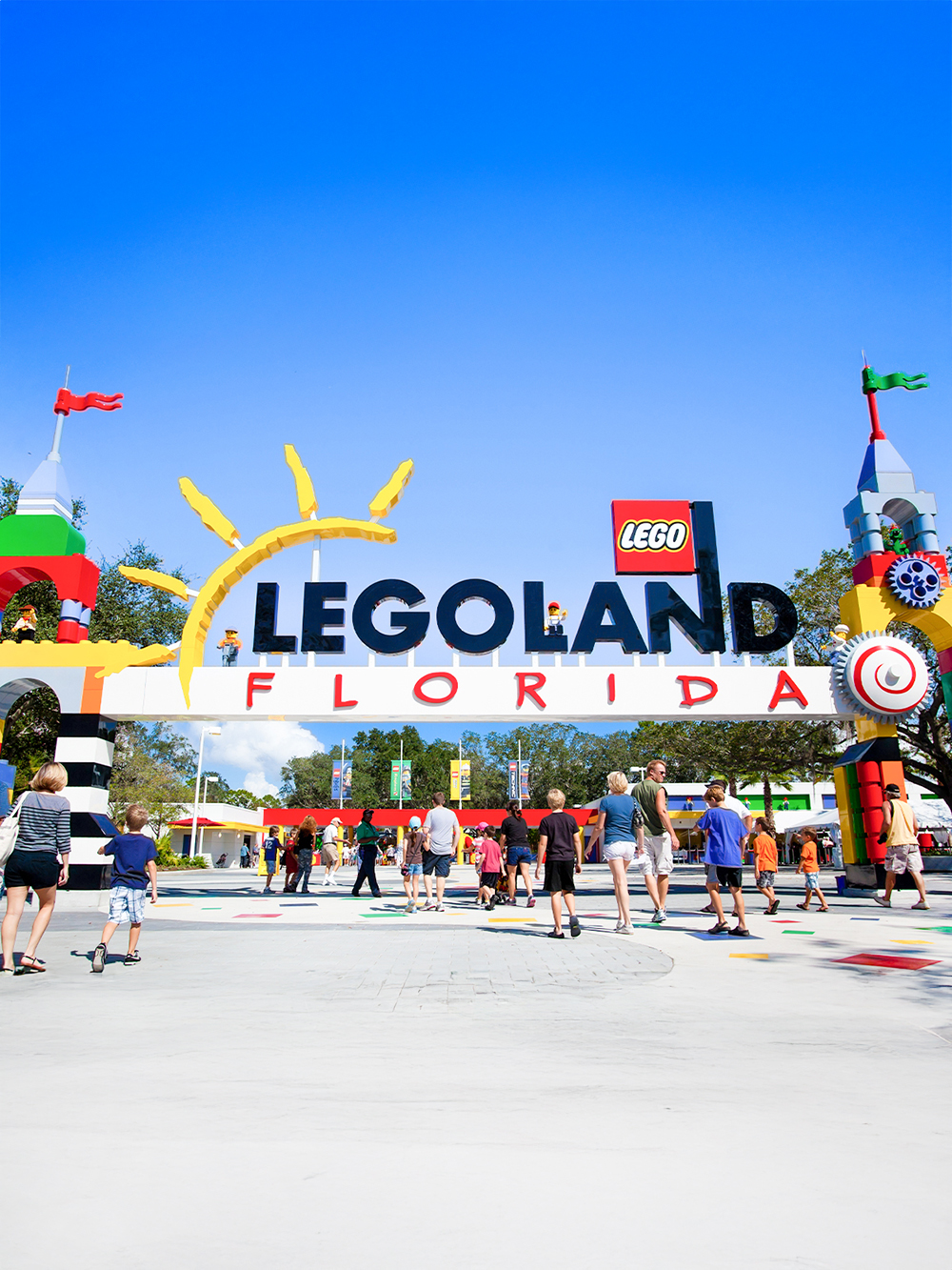 Visitors entering Legoland Florida under colorful entrance arch.