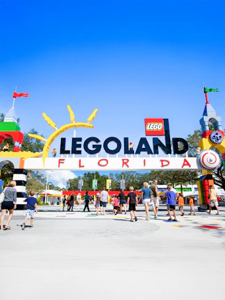 Visitors entering Legoland Florida under colorful entrance arch.