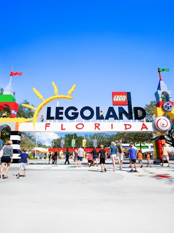 Visitors entering Legoland Florida under colorful entrance arch.
