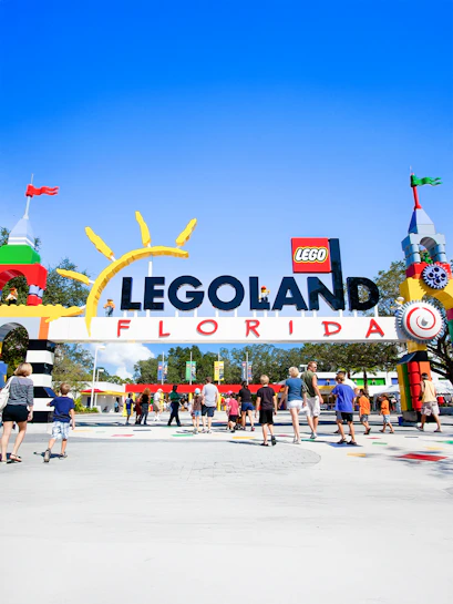 Visitors entering Legoland Florida under colorful entrance arch.