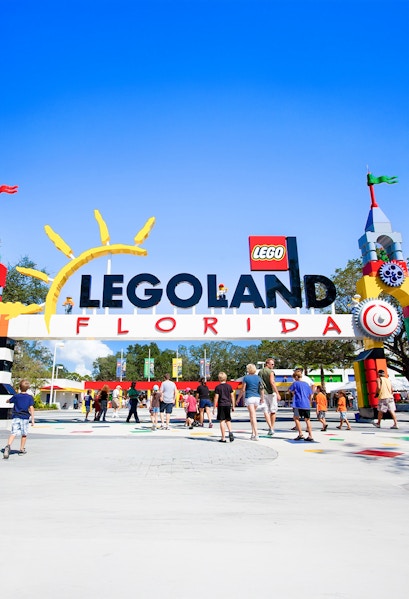 Visitors entering Legoland Florida under colorful entrance arch.
