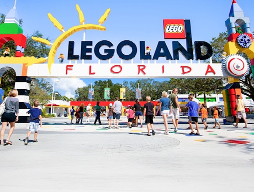 Visitors entering Legoland Florida under colorful entrance arch.