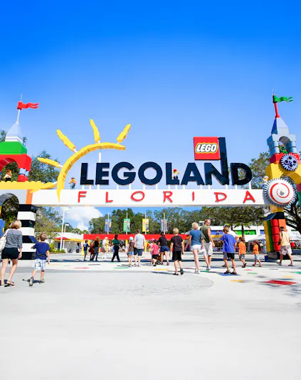 Visitors entering Legoland Florida under colorful entrance arch.