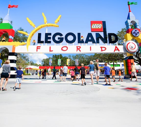Visitors entering Legoland Florida under colorful entrance arch.