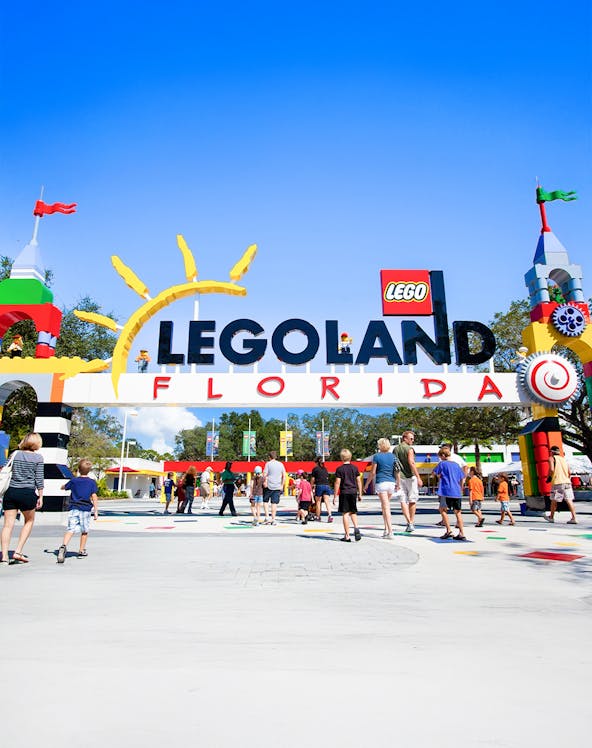 Visitors entering Legoland Florida under colorful entrance arch.