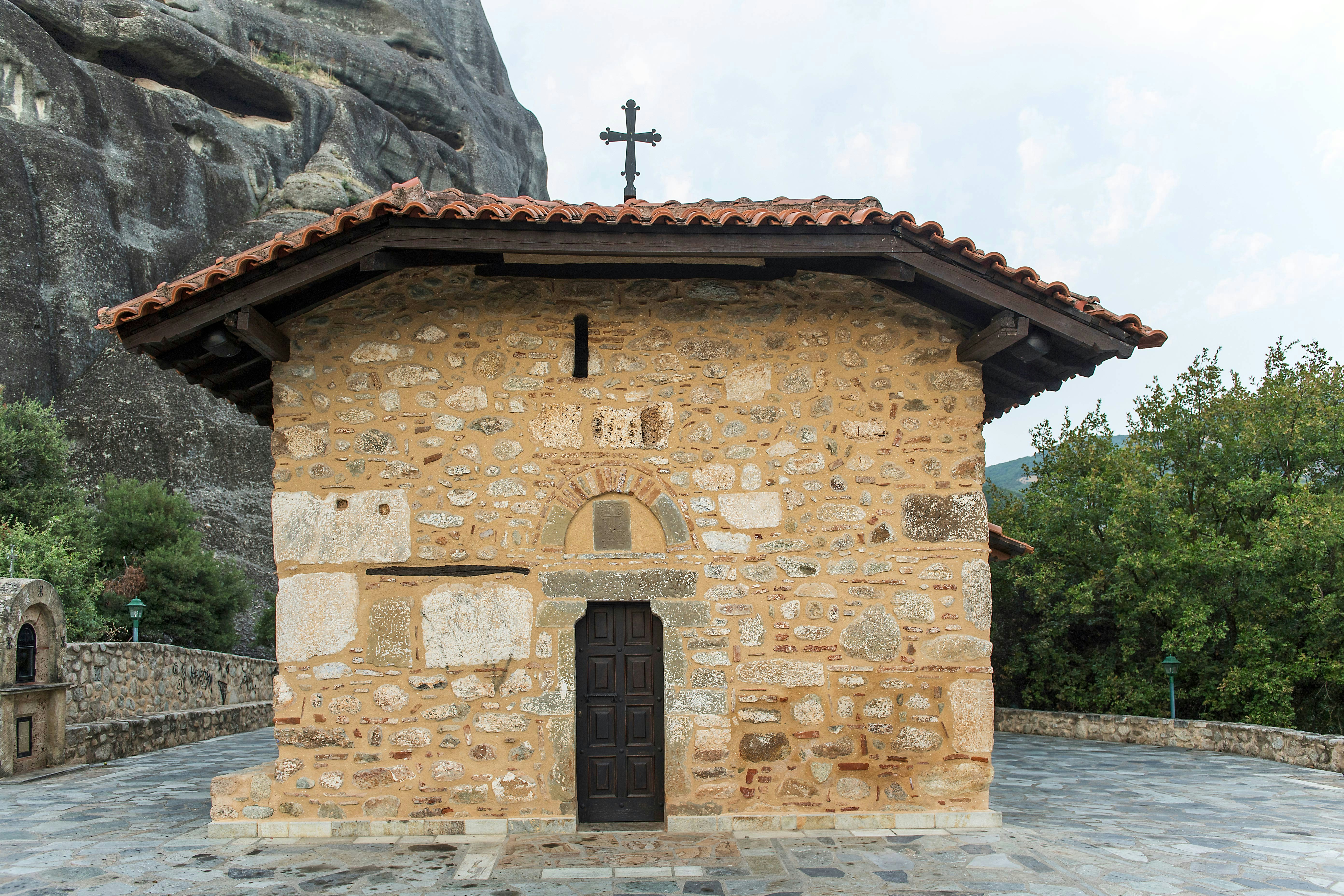 Chapel of Doupiani with stone facade and cross, Meteora, Greece.
