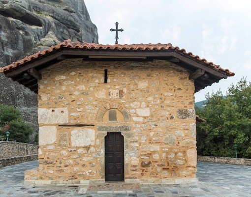 Chapel of Doupiani with stone facade and cross, Meteora, Greece.