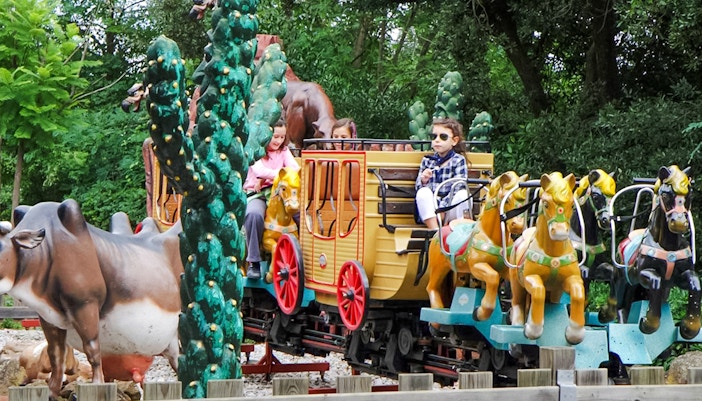 Children riding a pony-themed train at Tibidabo Amusement Park.