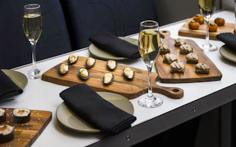 Gourmet canapés and champagne on a table during a Milford Sound cruise.