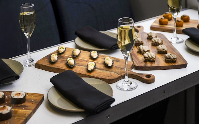 Gourmet canapés and champagne on a table during a Milford Sound cruise.
