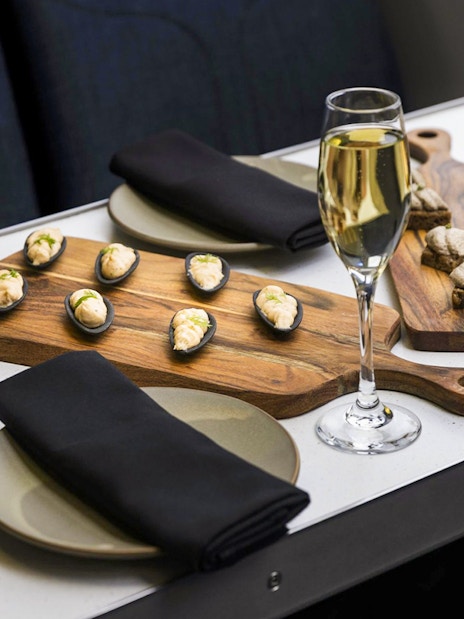 Gourmet canapés and champagne on a table during a Milford Sound cruise.