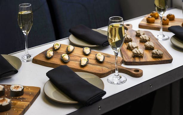 Gourmet canapés and champagne on a table during a Milford Sound cruise.