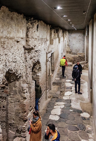 Visitors exploring ancient stone passageways in Naples Underground Tours.