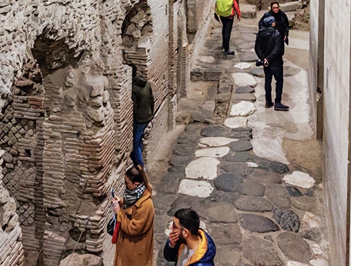 Visitors exploring ancient stone passageways in Naples Underground Tours.