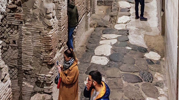 Visitors exploring ancient stone passageways in Naples Underground Tours.