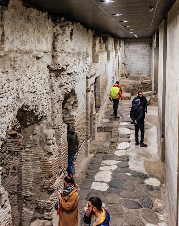 Visitors exploring ancient stone passageways in Naples Underground Tours.
