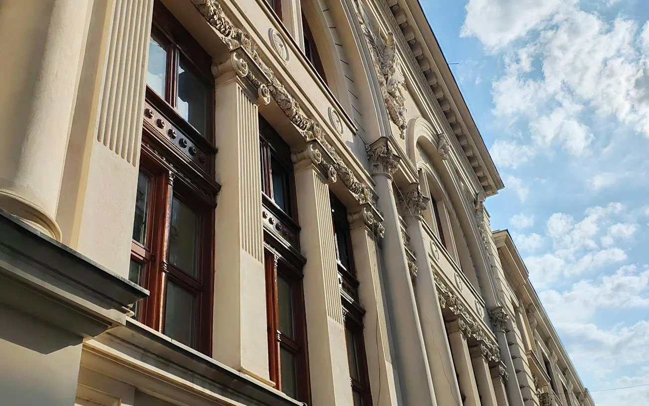 Historic building facade with ornate columns in Bucharest, part of the self-guided city exploration game.