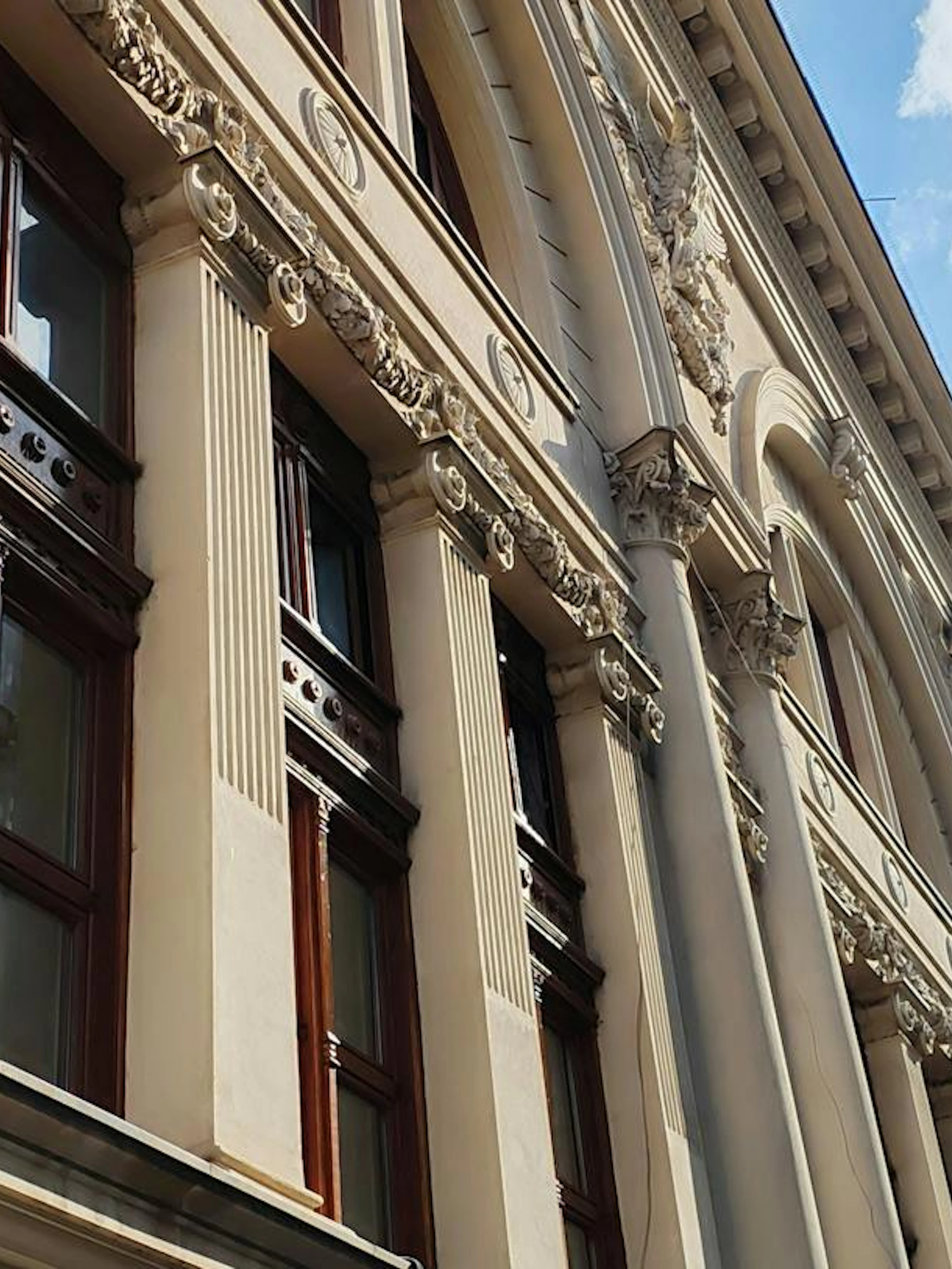 Historic building facade with ornate columns in Bucharest, part of the self-guided city exploration game.