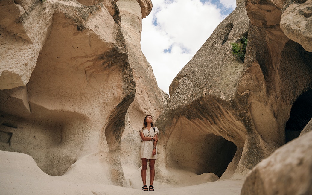 Guest exploring rock formations at Zelve Open Air Museum, Cappadocia.