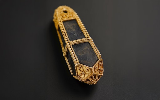 Viking Age gold and stone pendant with intricate design.