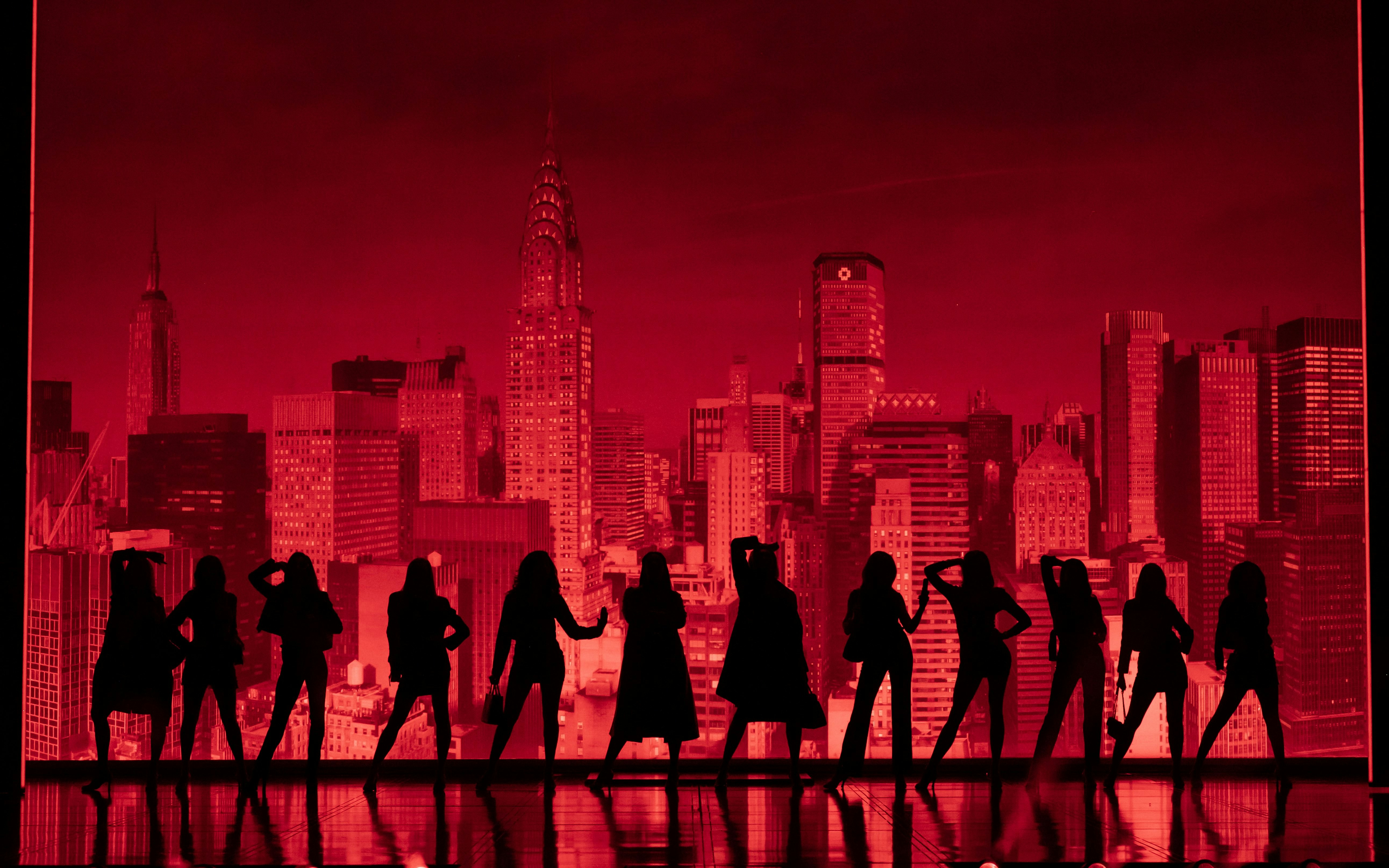 Silhouettes of performers on stage with New York City skyline backdrop during The Devil Wears Prada Westend show.