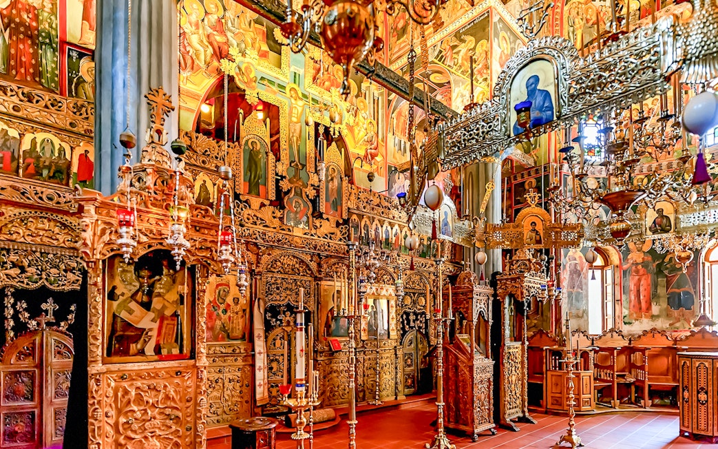 Interior of The Monastery of Great Meteoron with ornate religious icons and wooden carvings.