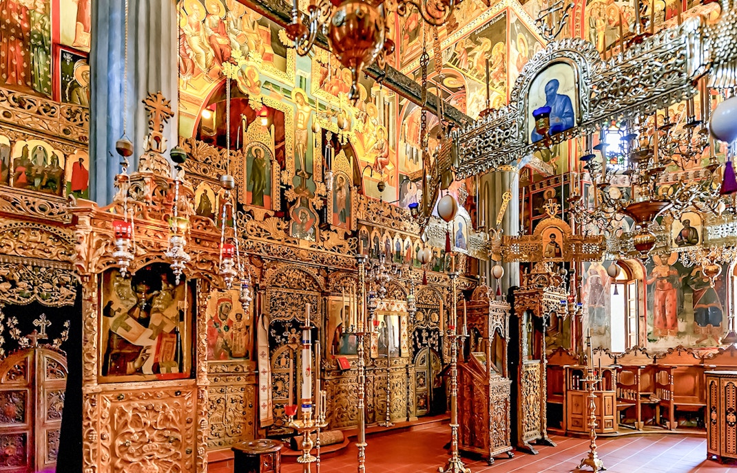 Interior of The Monastery of Great Meteoron with ornate religious icons and wooden carvings.