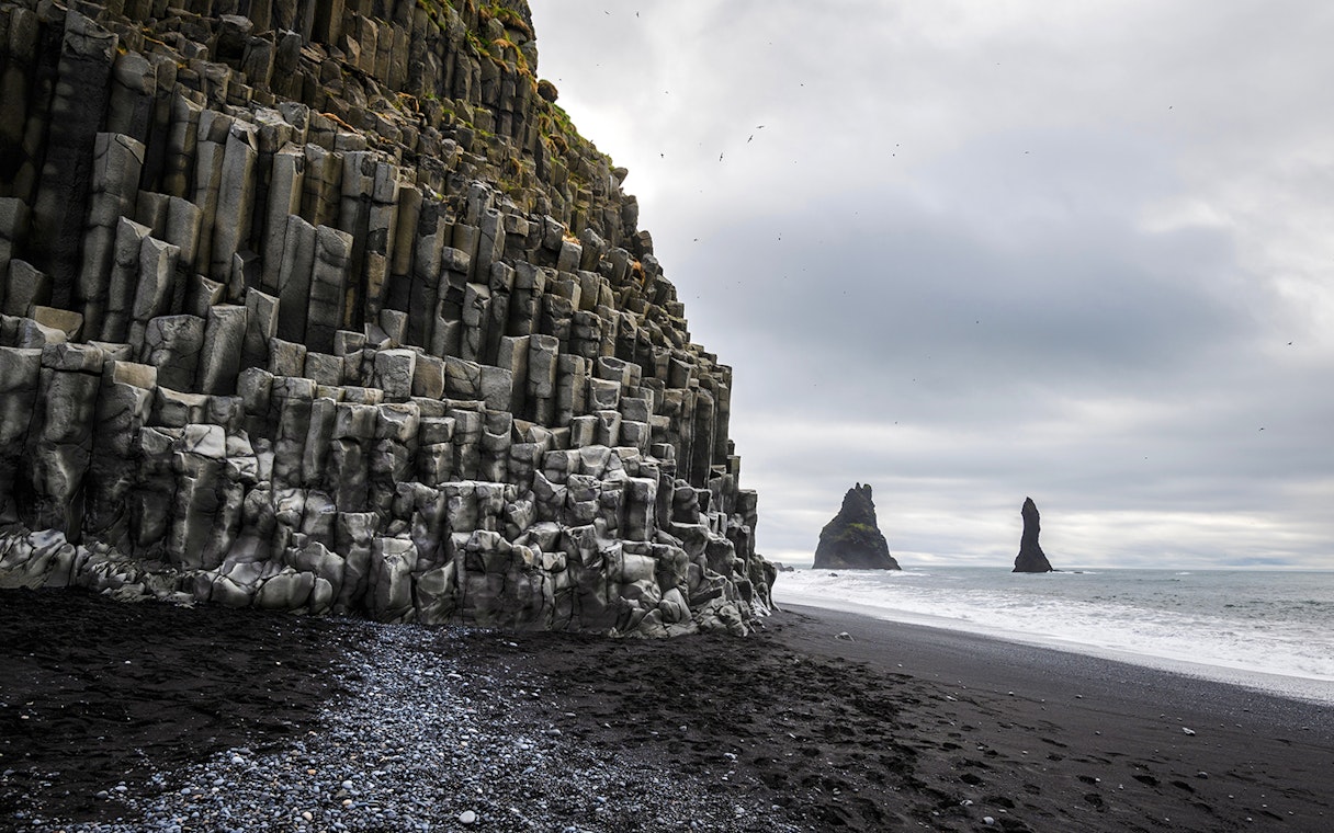 Basalt columns and sea stacks at Reynisfjara beach, Iceland.