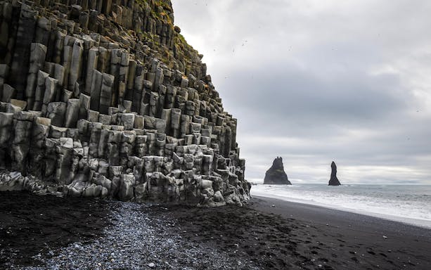 Basalt columns and sea stacks at Reynisfjara beach, Iceland.