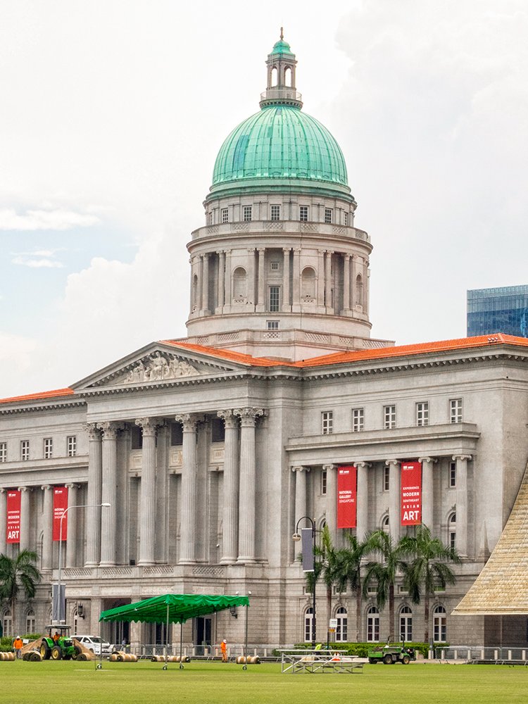 National Gallery Singapore exterior with dome and red banners.