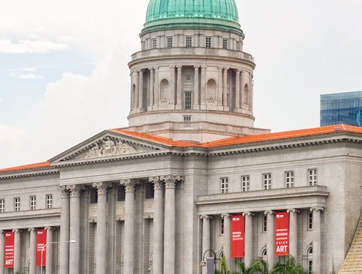National Gallery Singapore exterior with dome and red banners.