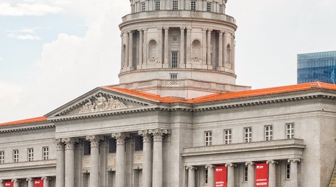 National Gallery Singapore exterior with dome and red banners.