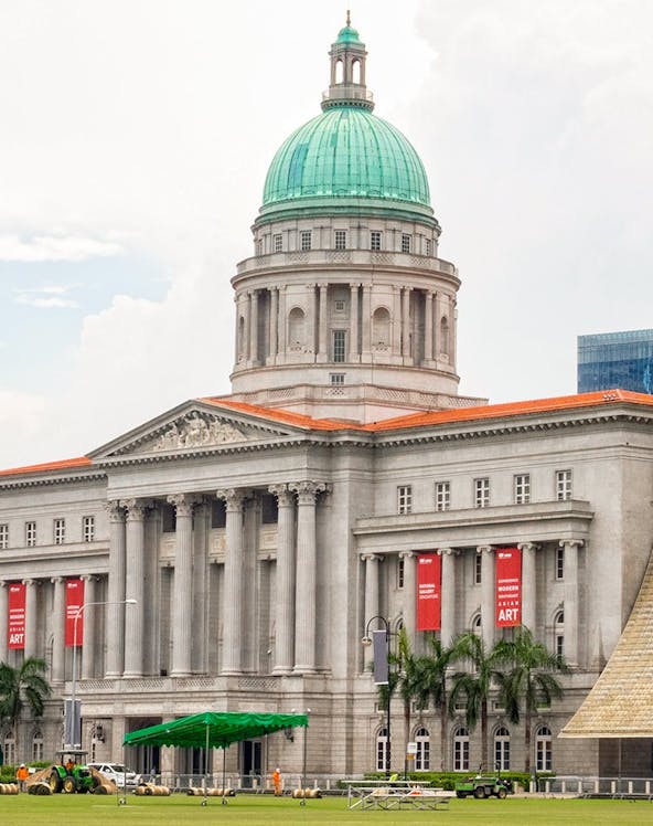 National Gallery Singapore exterior with dome and red banners.