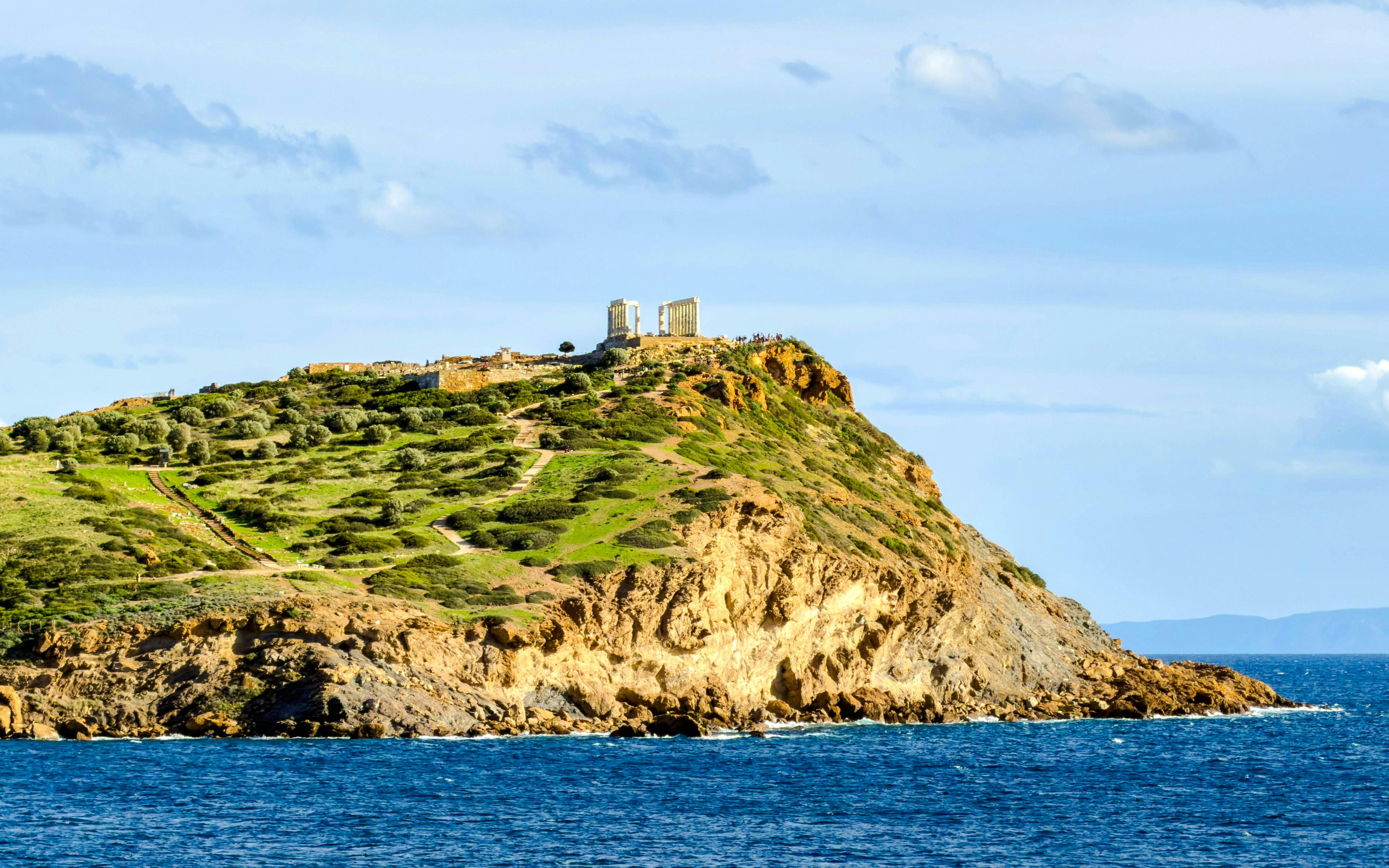 Cape Sounio with Poseidon Temple on hilltop overlooking the Aegean Sea.