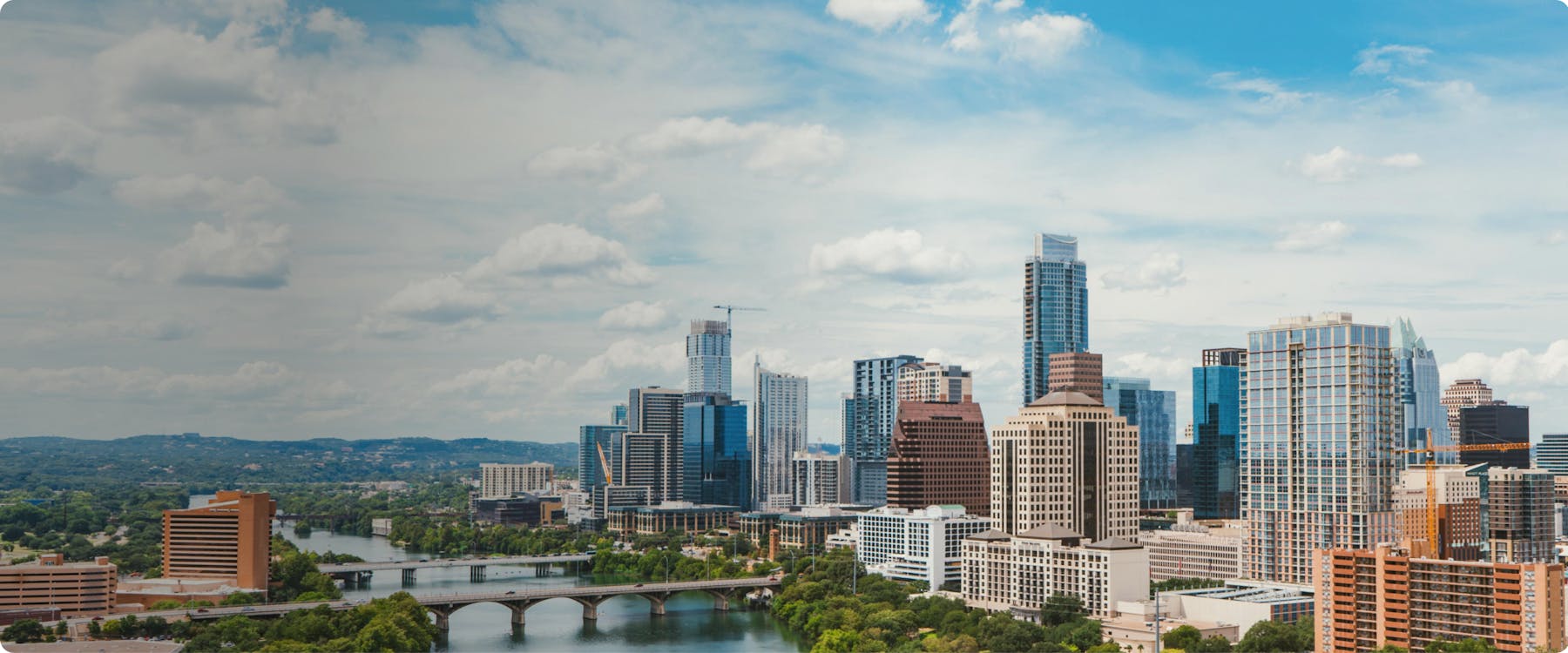 Austin skyline with high-rise buildings and a bridge over the river.
