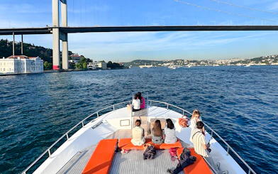 Passengers on yacht viewing Bosphorus Bridge in Istanbul.